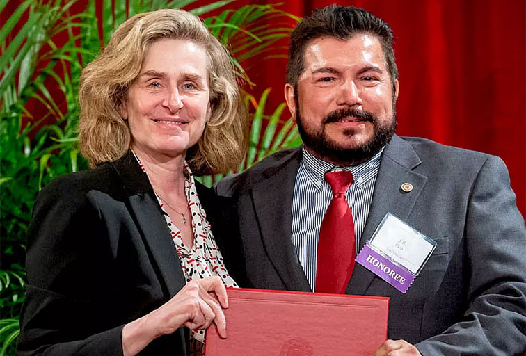 A photo of J.R. Pico receiving the W. George Pinnell Award for Outstanding Service from IU President Pamela Whitten.